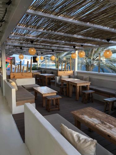 een restaurant met houten tafels en banken bij Elegant apartment next to the sea! in Corralejo