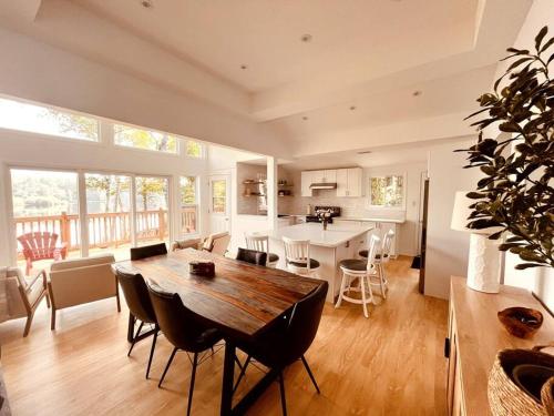 cocina y sala de estar con mesa de madera y sillas en Nala's Lake House Retreat, 