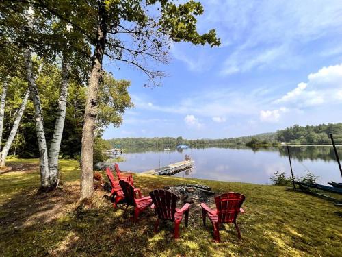 a group of red chairs sitting next to a lake at Nala's Lake House Retreat 