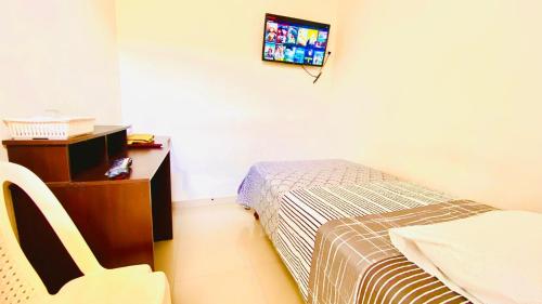 1 dormitorio con 1 cama y TV en la pared en Garden House Piura, en Piura