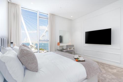ドバイにあるBluewaters Luxe 3BR with maids room - Panoramic Sea View - CityApartmentStayの白いベッドルーム(大型ベッド1台、大きな窓付)