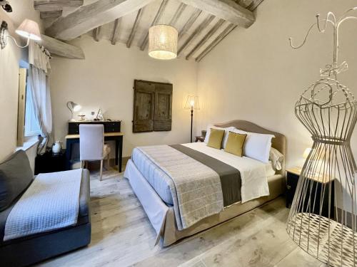 a bedroom with a bed and a desk and a chair at Vento d’Orcia in Pienza