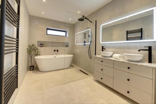 a bathroom with two sinks and a bath tub at Kist Accommodates presents - Hygge House in Ripon