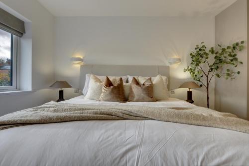 a white bedroom with a large white bed with pillows at Kist Accommodates presents - Hygge House, Parking, EV Point in Ripon