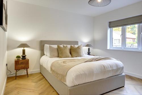 a white bedroom with a bed and a window at Kist Accommodates presents - Hygge House, Parking, EV Point in Ripon