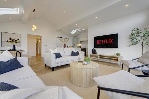 a living room with white furniture and a tv at Kist Accommodates presents - Hygge House, Parking, EV Point in Ripon