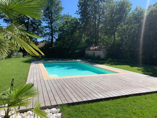 una piscina en un patio con terraza de madera en Au Coeur de la Provence, en Éguilles