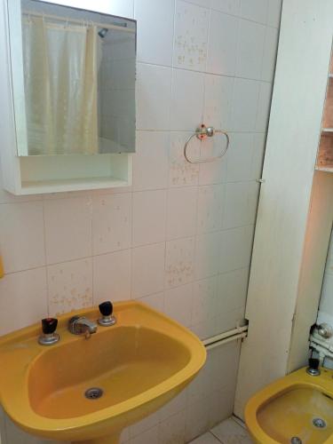 bagno con lavandino giallo e specchio di Hospedaje La Feliz a Mar del Plata
