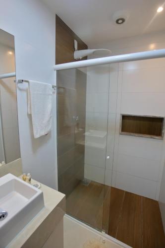 a bathroom with a glass shower and a sink at Recanto Novo Premium Flat in Cabo Frio