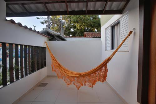 a hammock on the balcony of a house at Recanto Novo Premium Flat in Cabo Frio