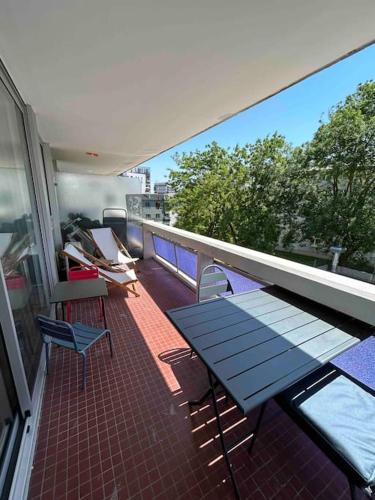 - un balcon avec une table bleue et des chaises dans un bâtiment dans l'établissement Superbe appartement, terrasse, accès direct RER, à Massy