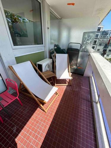 2 Stühle auf einem Balkon mit Fenster in der Unterkunft Superbe appartement, terrasse, accès direct RER in Massy