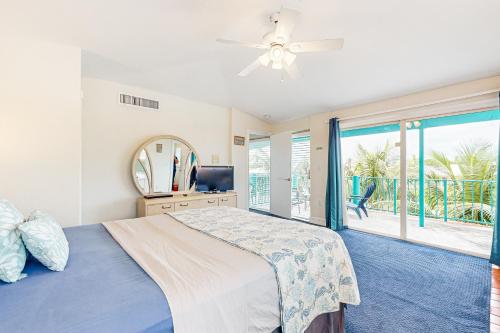 a bedroom with a bed and a large window at Breezy Palms & Tropical Charm in Key Colony Beach