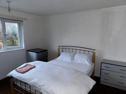 a bedroom with a white bed and a window at Patchway Homestay in Bristol