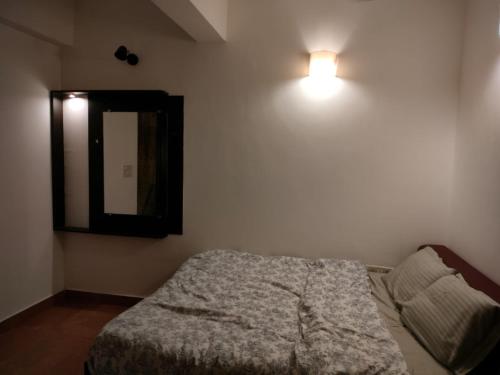1 dormitorio con cama y espejo en la pared en Zen Living, en Anjuna