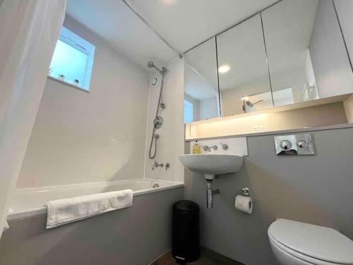ein weißes Bad mit einem Waschbecken und einem WC in der Unterkunft Camden Loft Apartment! in London