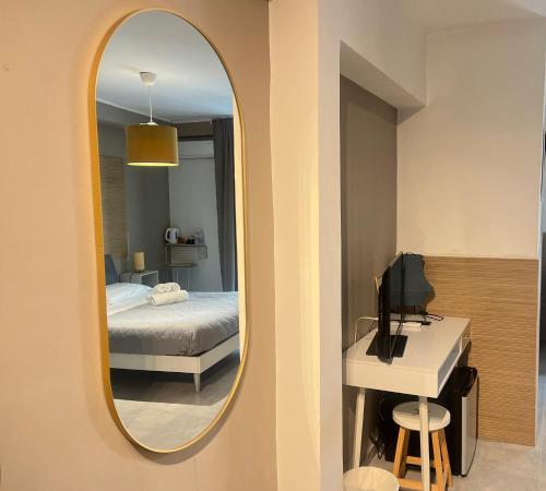 um quarto com um espelho, uma cama e uma secretária em B&B Stesicoro InHabit - GuestHouse City Center em Catânia