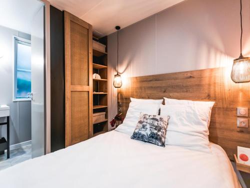 a bedroom with a large white bed with a wooden headboard at Wadden Lodge Living in Westerland