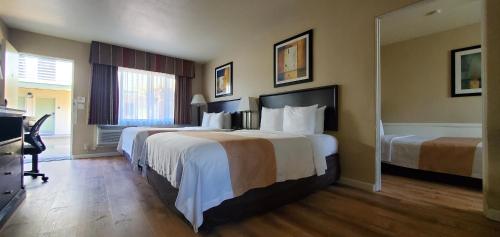 a hotel room with two beds and a television at Quality Inn & Suites Anaheim at the Park in Anaheim
