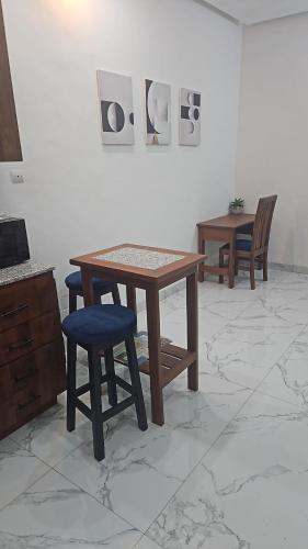 コトヌーにあるStudio Le Cosi, Cotonouのテーブルと椅子が備わる客室です。