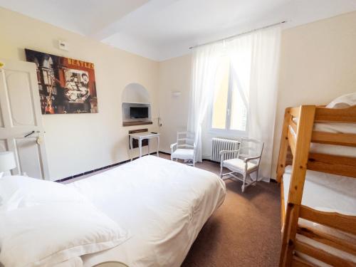 une chambre avec un lit, un bureau et des chaises dans l'établissement Auberge de la Tour, à Aups