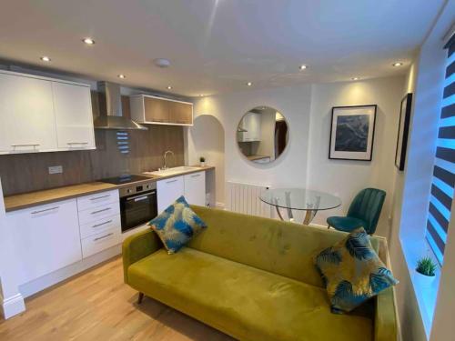 sala de estar con sofá verde en la cocina en The Suite Apartment @3 en Barnsley