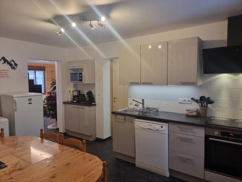 a kitchen with a wooden table and a dining room at Le Ruisseau à Bussang Htes Vosges tout confort in Bussang