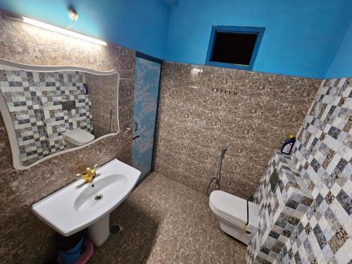 a bathroom with a sink and a toilet at Sunlit stays-Forest view in Lucknow
