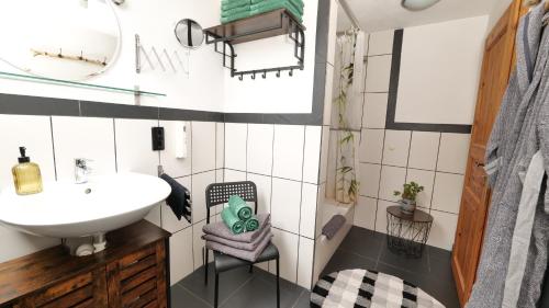 a bathroom with a sink and a chair at Green Loft Schwarzwald - 120qm - Dach-Balkon in Winzeln