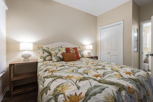 - une chambre dotée d'un lit avec un couvre-lit floral dans l'établissement Tidewater 304-Family friendly complex to enjoy the Beach!, à Orange Beach