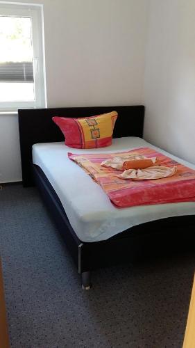 ein Bett mit zwei Kissen auf einem Zimmer in der Unterkunft Ferienhaus Katja in Göhren