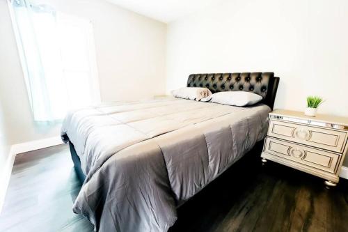 1 dormitorio con 1 cama con tocador y ventana en The Ashland Manor 4BR en Niagara Falls