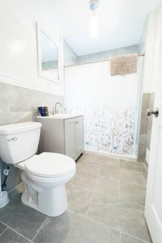 a white bathroom with a toilet and a shower at 4BR Niagara Getaway-Prime Location in Niagara Falls