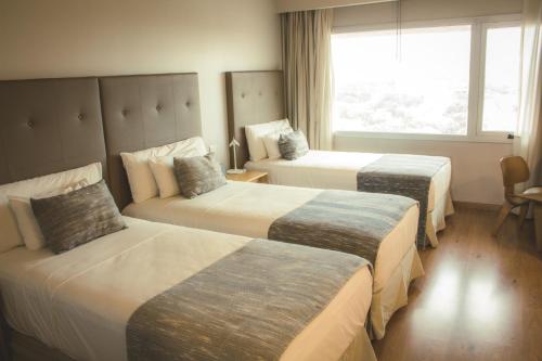 um quarto de hotel com duas camas e uma janela em Dazzler by Wyndham Asuncion em Assunção