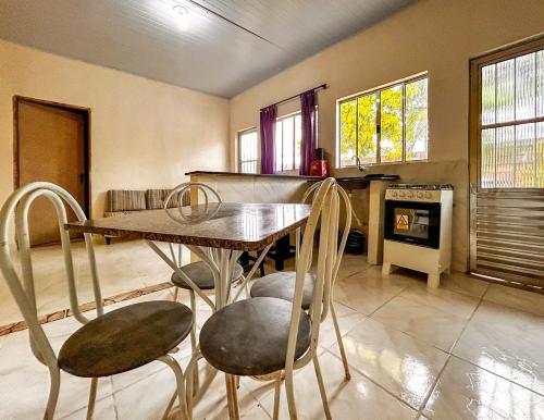a kitchen with a table and chairs in a room at Otima chacara com Wi-Fi em Mongagua SP in Mongaguá