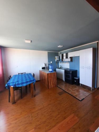 a living room with a table and a kitchen at Cabaña in Pichidangui