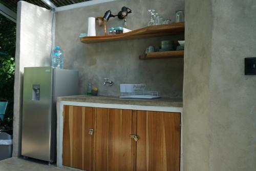 a kitchen with a sink and a refrigerator at Serenity Glamping in Puerto Viejo