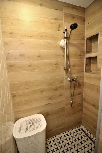 a bathroom with a shower with wooden walls at Apartament Kaszmirowy in Sławno