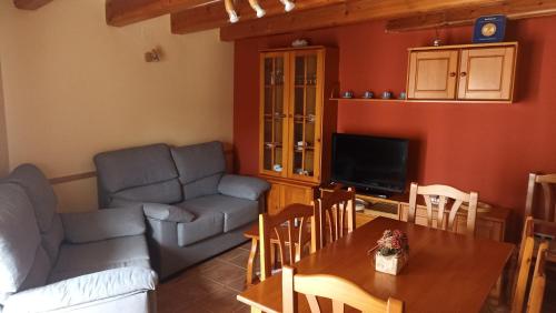 ein Wohnzimmer mit einem Sofa und einem Tisch in der Unterkunft Casa La Catalina II in Beceite