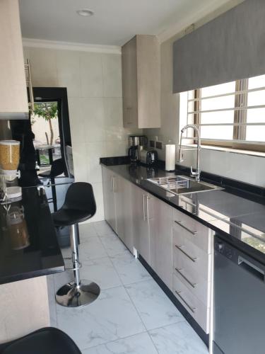 a kitchen with a sink and a counter top at Lovely 1 bedroom self catering apartment in Lusaka