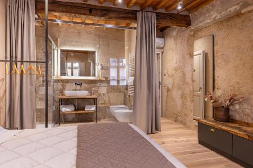 een slaapkamer met een groot bed en een badkamer bij Truffle House Tuscany Tuber Melanosporum Vitt in Montepulciano