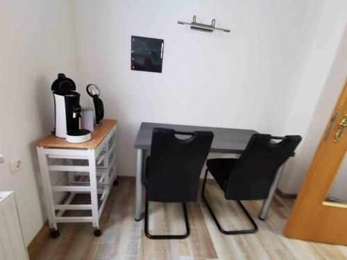 a desk with two chairs and a table with a coffee maker at Ferienwohnung Winzer in Annaberg-Buchholz