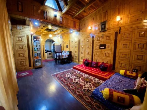a living room with a red couch and a rug at The Wooden Lodge in Nainital
