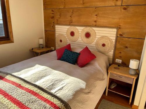 1 dormitorio con 1 cama con pared de madera en Cabaña en Malalcahuello, en Malalcahuello