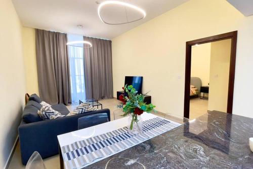 a living room with a blue couch and a table at Azizi Luxurious 1 Bed Room apartment, Near Metro, Fully Furnished in Dubai