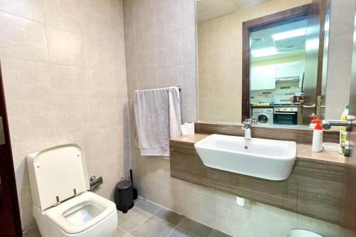 a bathroom with a sink and a toilet and a mirror at Azizi Luxurious 1 Bed Room apartment, Near Metro, Fully Furnished in Dubai