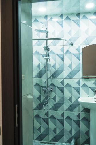 a blue tiled bathroom with a shower and a sink at Garni Nature Villa in Garni