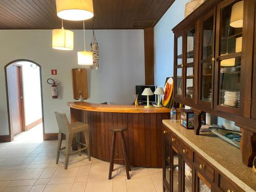 a bar in a kitchen with a counter and chairs at Deck da Villa Picinguaba in Ubatuba