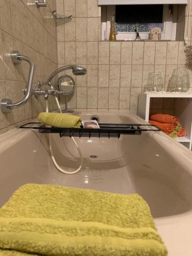 vasca da bagno con asciugamano verde e rubinetto di Zwei Zimmer Natur und Luxus Ferienwohnung mit Garten a Schmilau