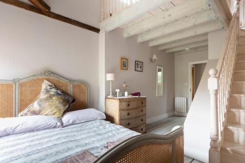 a bedroom with a bed and a wooden dresser at Luxury Apartment, The Barn, Cookham in Cookham